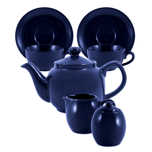 Navy blue ceramic tea set with teapot, cups, and sugar bowl on a white background