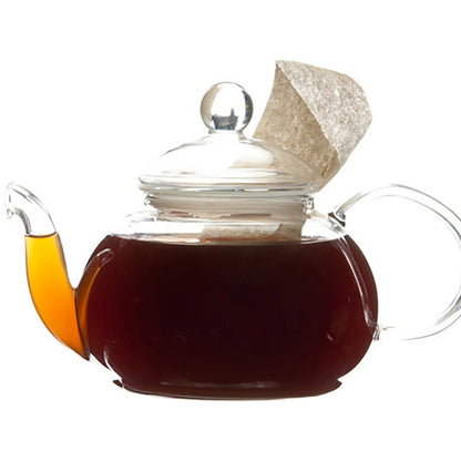 Dark amber colored black tea in a glass teapot with a teabag