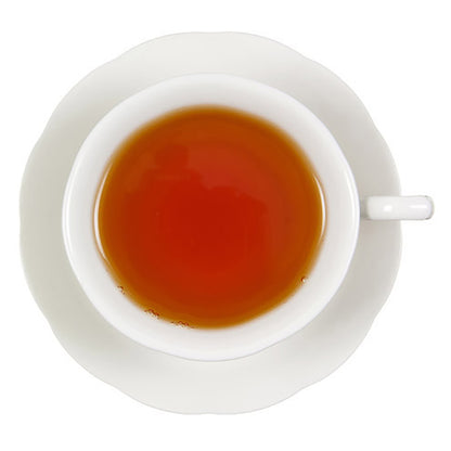 White teacup with red tea on a white background