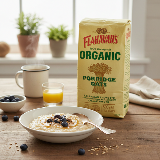 Flahavan's Organic Porridge Oats packaging with a bowl of porridge and breakfast items on a wooden table.