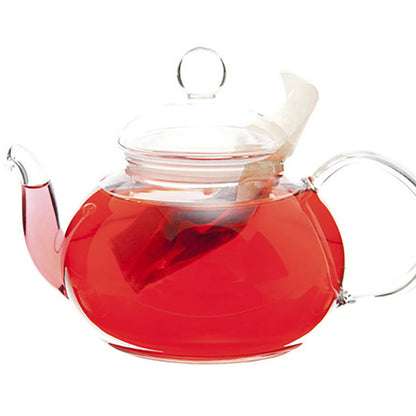 Glass teapot on a white background with a teabag inside and hot red colored tea