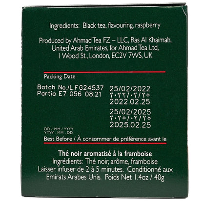 Side view of a box of Ahmad Tea Raspberry Indulgence black tea packaging with raspberries on a white background