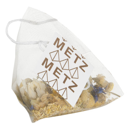 Pyramid style teabag with camomile tea and a Metz label.