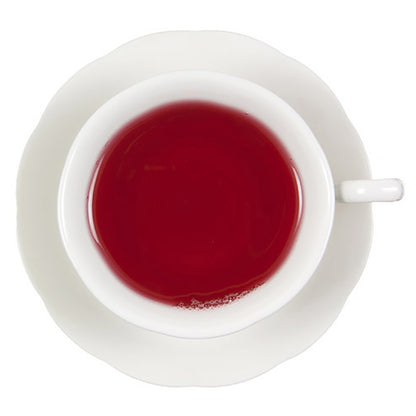 Top down view of a white teacup with red hot tea on a white background