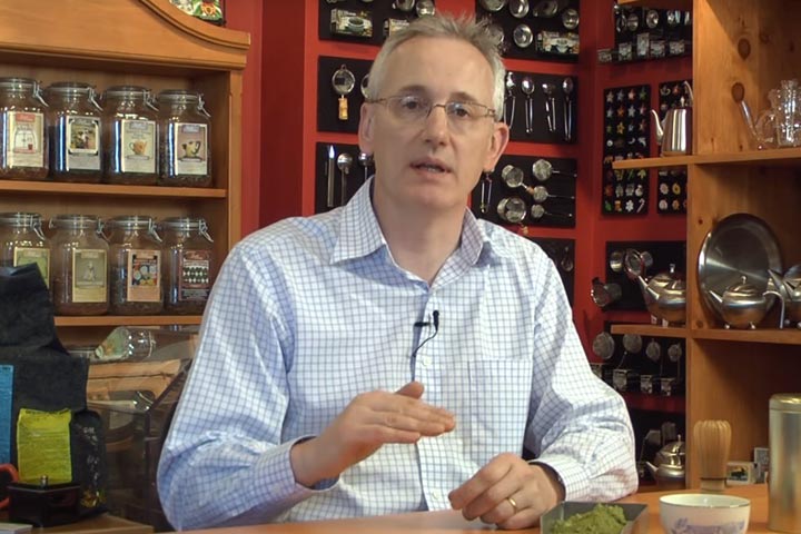 A man in a tea shop holding an online discussion