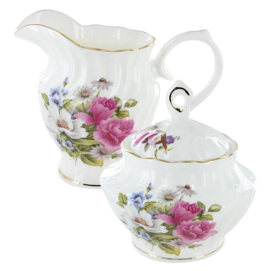 Two rose bone pitchers with floral designs on a white background