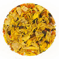 Close-up of a round ball of dried tea leaves, dried yellow flower petals, and dried fruit pieces on a white background