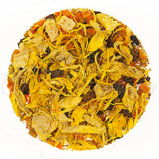 Close-up of a round ball of dried tea leaves, dried yellow flower petals, and dried fruit pieces on a white background