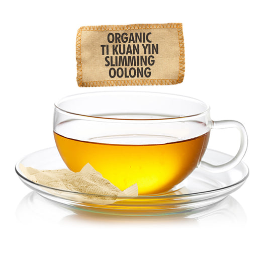 Glass cup of tea with a tea bag labeled 'Organic Ti Kuan Yin Slimming Oolong' on a white background
