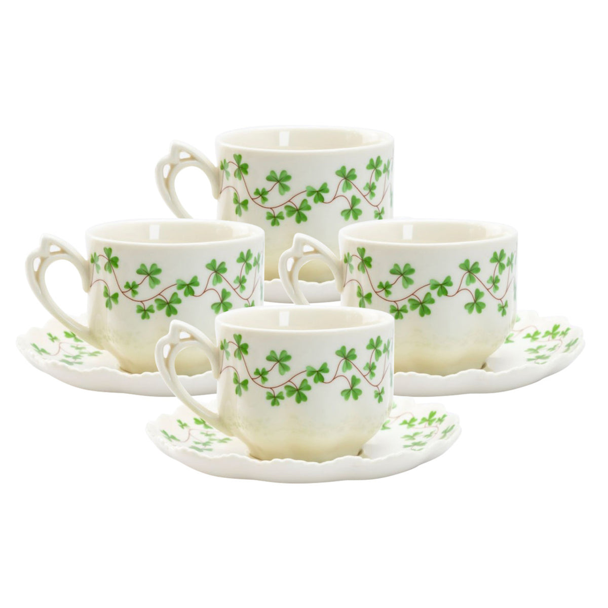 Set of four teacups and saucers with green leaf patterns on a white background