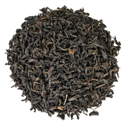 Pile of black dried tea leaves on a white background