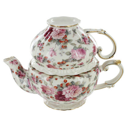 Floral-patterned porcelain teapot and matching teacup on a white background