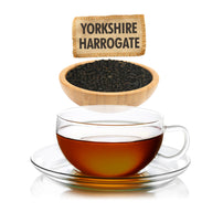 Glass cup of tea with a bowl of tea leaves and a sign reading 'Yorkshire Harrogate'.