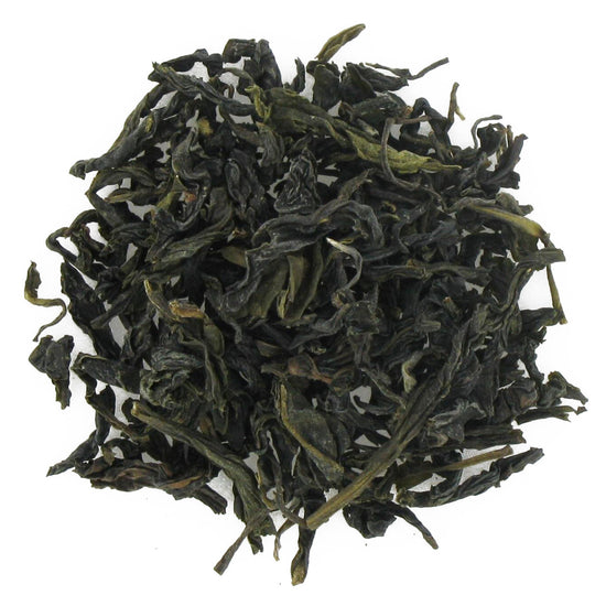 Dry green tea leaves on a white background