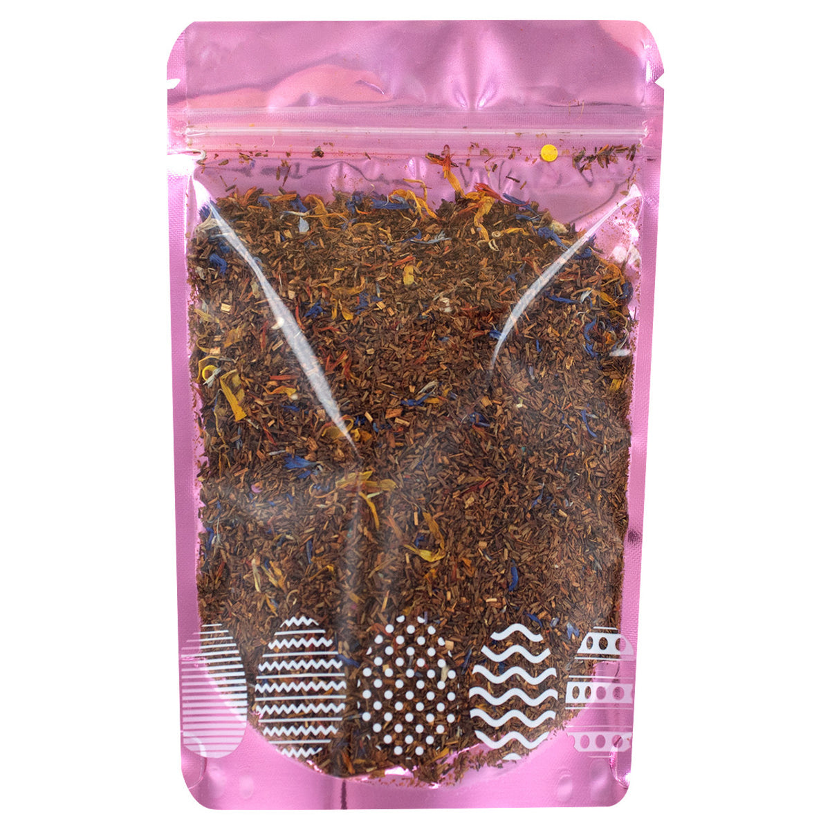 Pink packaging of a tea blend with visible leaves on a white background