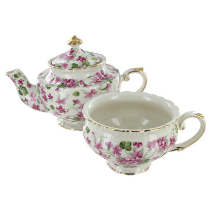 Porcelain teapot and teacup set with floral design on a white background