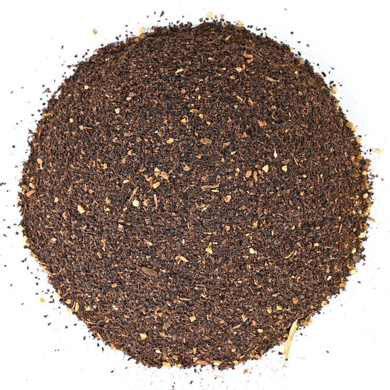 Round pile of coarse ground black loose-leaf tea.