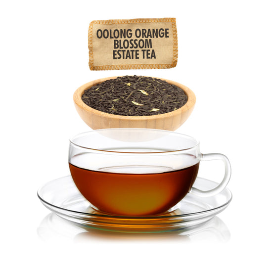 Glass cup of Oolong Orange Blossom Estate Tea with tea leaves in a wooden bowl and product label.