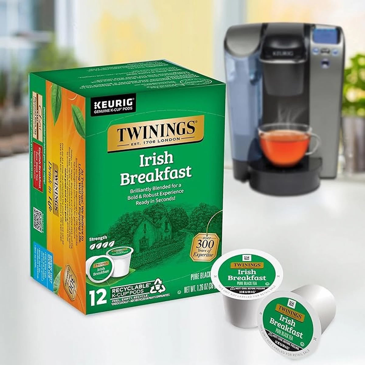 Twinings Irish Breakfast Keurig K-Cup pods with a Keurig machine in the background.