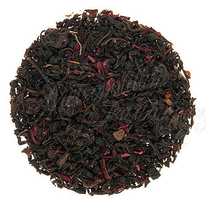 Tea ball with black tea leaves and red flowers on a white background