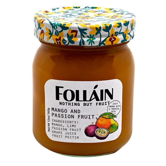 Jar of Folláin mango and passion fruit spread with a decorative lid on a white background.