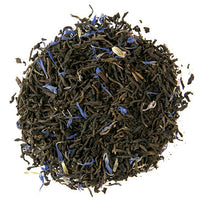 A close-up of loose leaf Earl Grey tea with visible black tea leaves and blue cornflower petals.