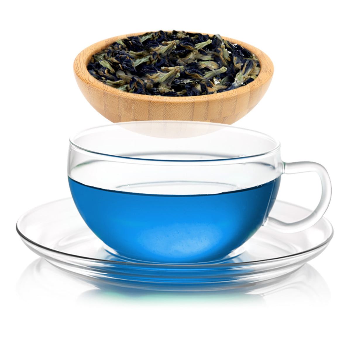 Clear glass cup with blue liquid tea and wooden bowl with tea leaves on a white background.