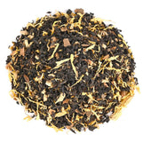 Loose-leaf black tea with dried spices and fruit pieces mixed with yellow petals.