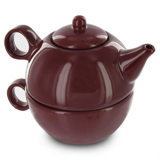Burgundy ceramic tea for one set with teapot stacked on teacup on a white background