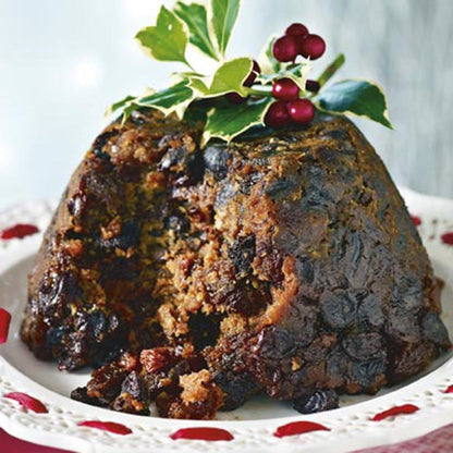 Close up of a Christmas Pudding desert on a plate with a portion already consumed
