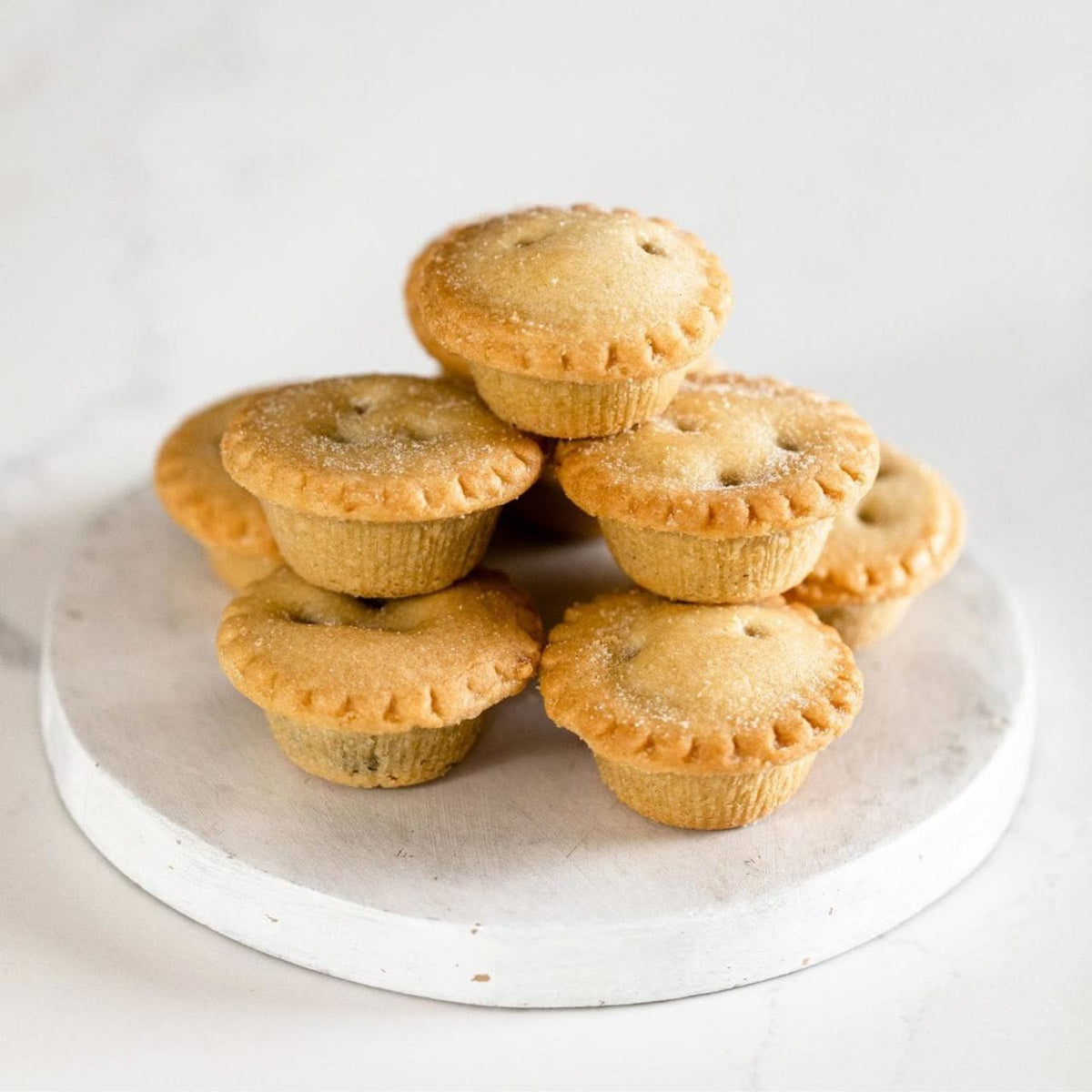 A stack of Walker's Mini Mintz pies on a stone circular cutting board
