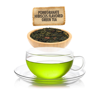 Glass cup of green tea with pomegranate hibiscus flavor, tea leaves in a bowl, and product label.