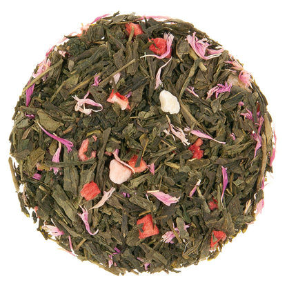 Green tea leaves with dried red fruit pieces and other fruit pieces along with light purple and pink flower petals intertwined on a white background.