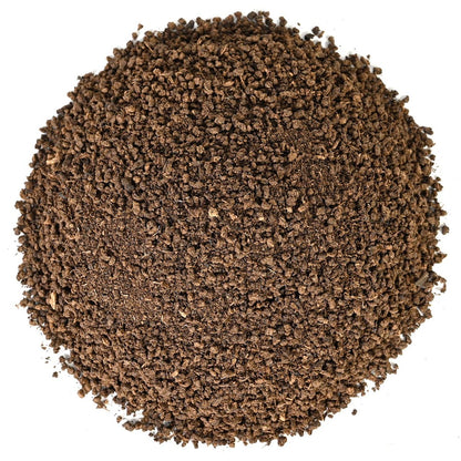 Close-up of dark loose leaf coarse ground black tea leaves on a white background