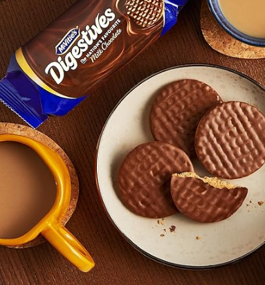 Chocolate digestive cookies on a plate with Nestle Digestives packaging and a cup of coffee.