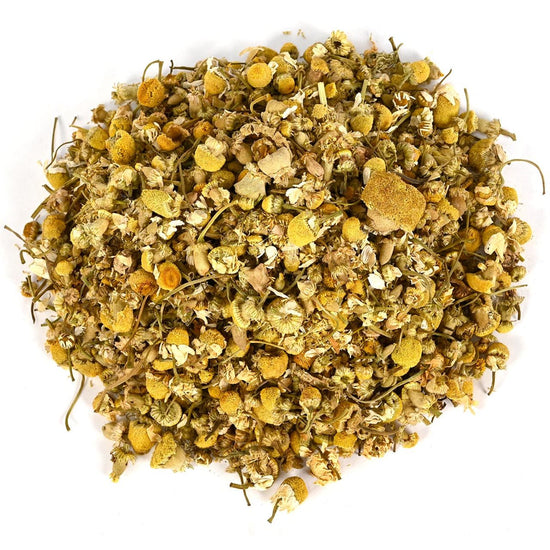 Pile of dried chamomile flowers and loose-leaf tea on a white background