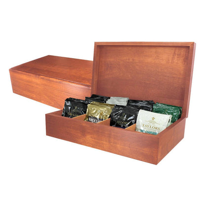A wooden tea chest open to display various colored tea bags organized in compartments.