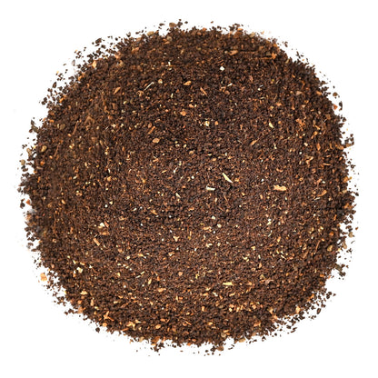 Close-up of ground black tea leaves on a white background