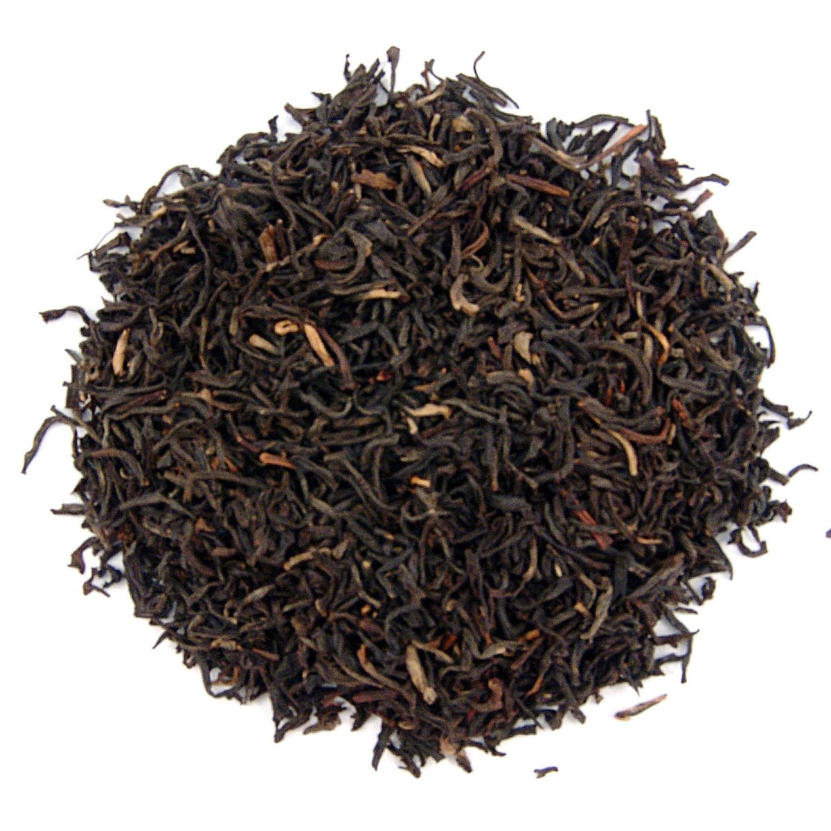 Close-up of dried black tea leaves on a white background