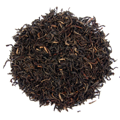 Close-up of dried black tea leaves on a white background