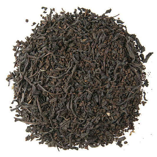Close-up of dark brown tea leaves on a white background