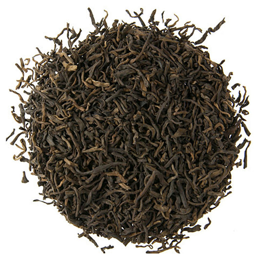 Close-up of dark brown tea leaves on a white background