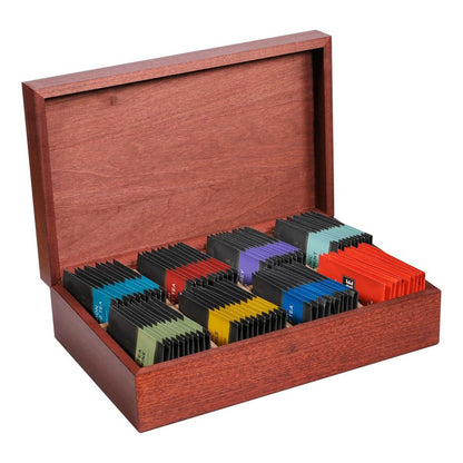 Wooden box with colorful individually wrapped teabags inside on a white background