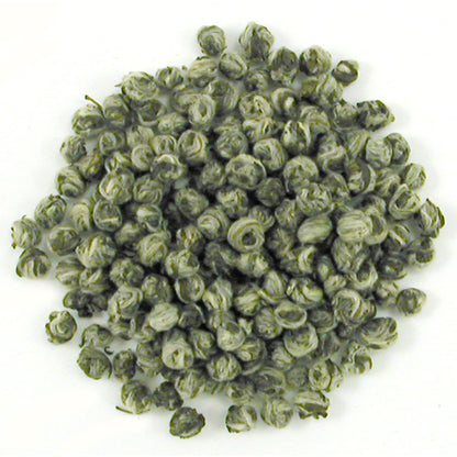 Close-up of green tea pearl shaped leaves on a white background