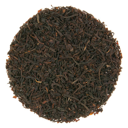 Close-up of dark brown tea leaves on a white background