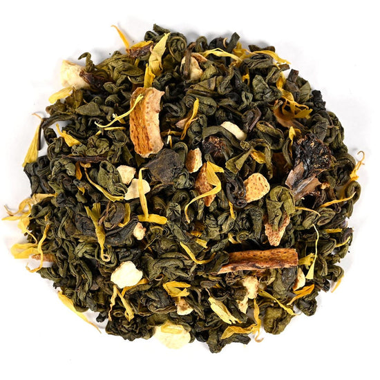 Tea leaves with visible spices and flowers on a white background
