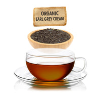 Glass cup of organic Earl Grey cream tea with tea leaves in a bowl and label above.