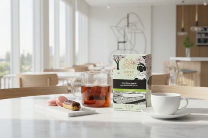 Tea set with Metz & Co tea packaging on a table in a bright room.