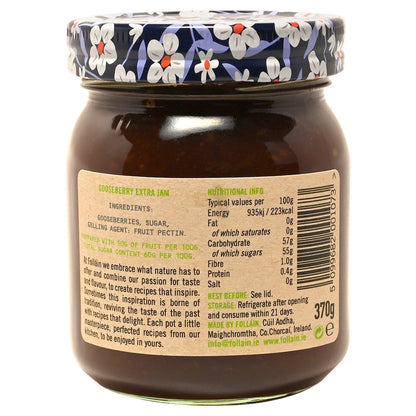 Jar of Folláin gooseberry jam with decorative lid and a label featuring ingredients and nutrition information with the jar on a white background