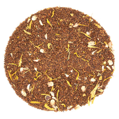 Round pattern of dry amber colored tea leaves on a white background
